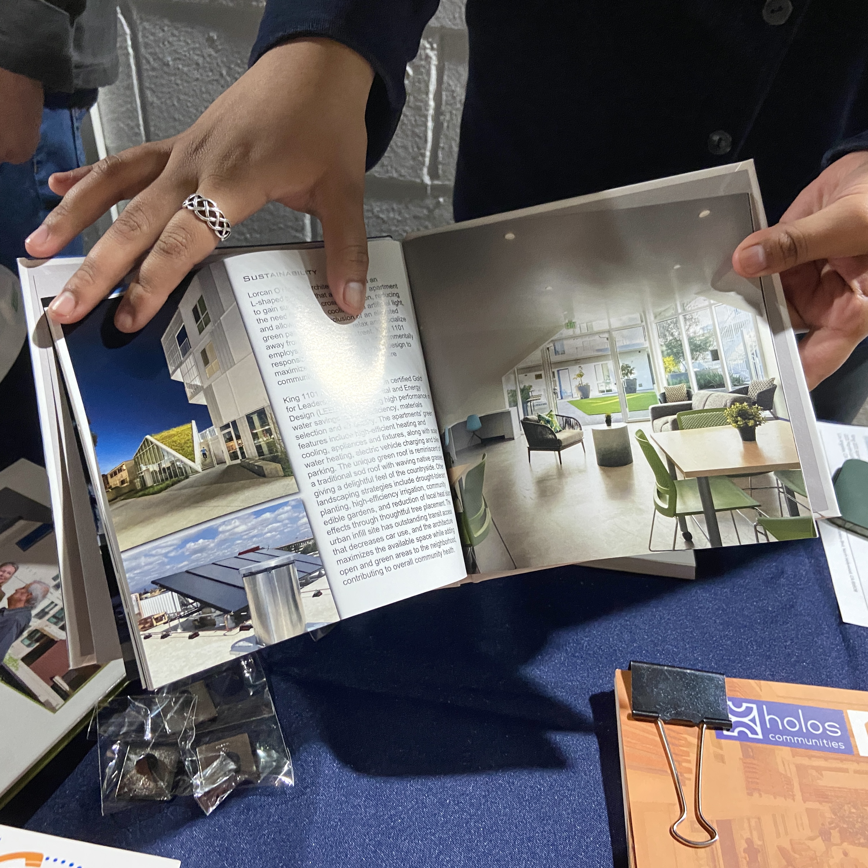 A person showing a booklet with information on sustainable housing.